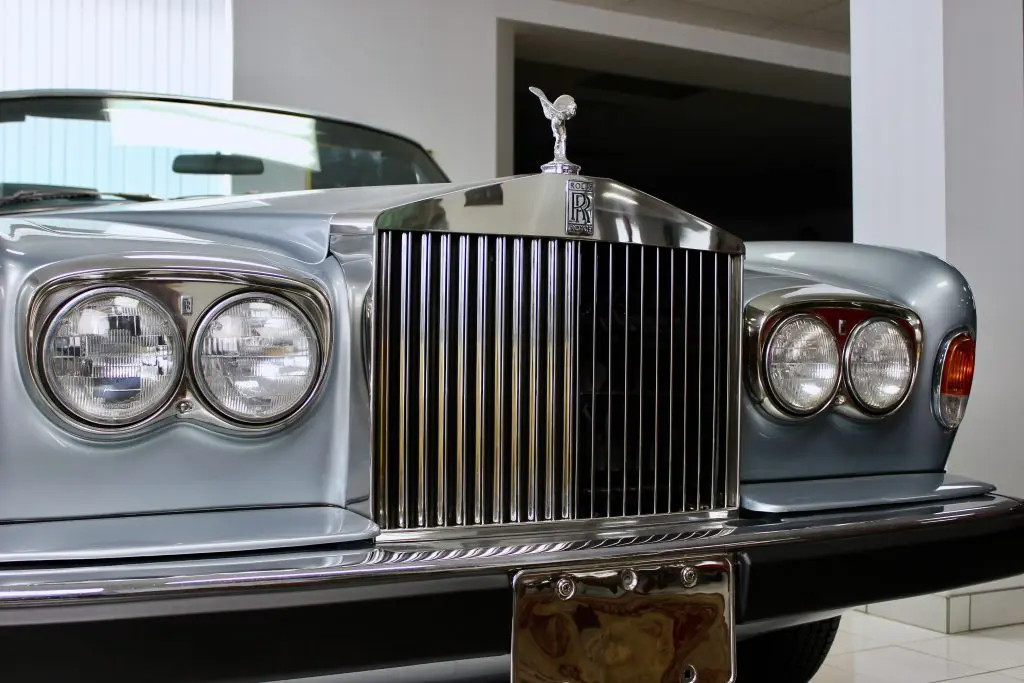 Front view of a blue Rolls-Royce Corniche. The grille, mascot and logo are clearly visible.