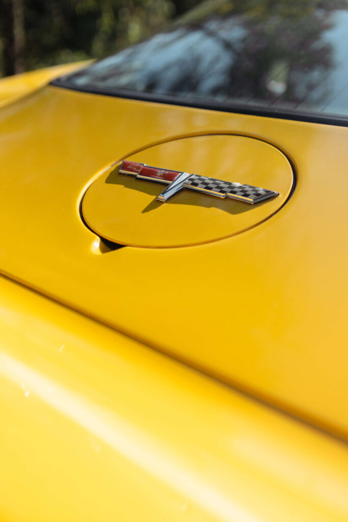 Close up of the Corvette logo on the fuel tank lid of a 1980 yellow Corvette