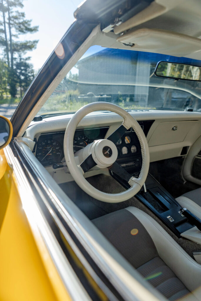 View through the window of the wheel of a 1980 yellow Corvette