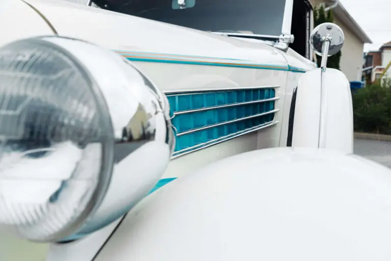 Detail of the side grille of a white Auburn 654. The inside of the grille is blue, an example of the art deco style
