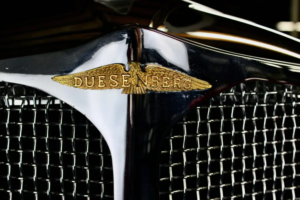 Close up of the Duesenberg logo.  "Duesenberg" is written inside the open wings of an eagle.