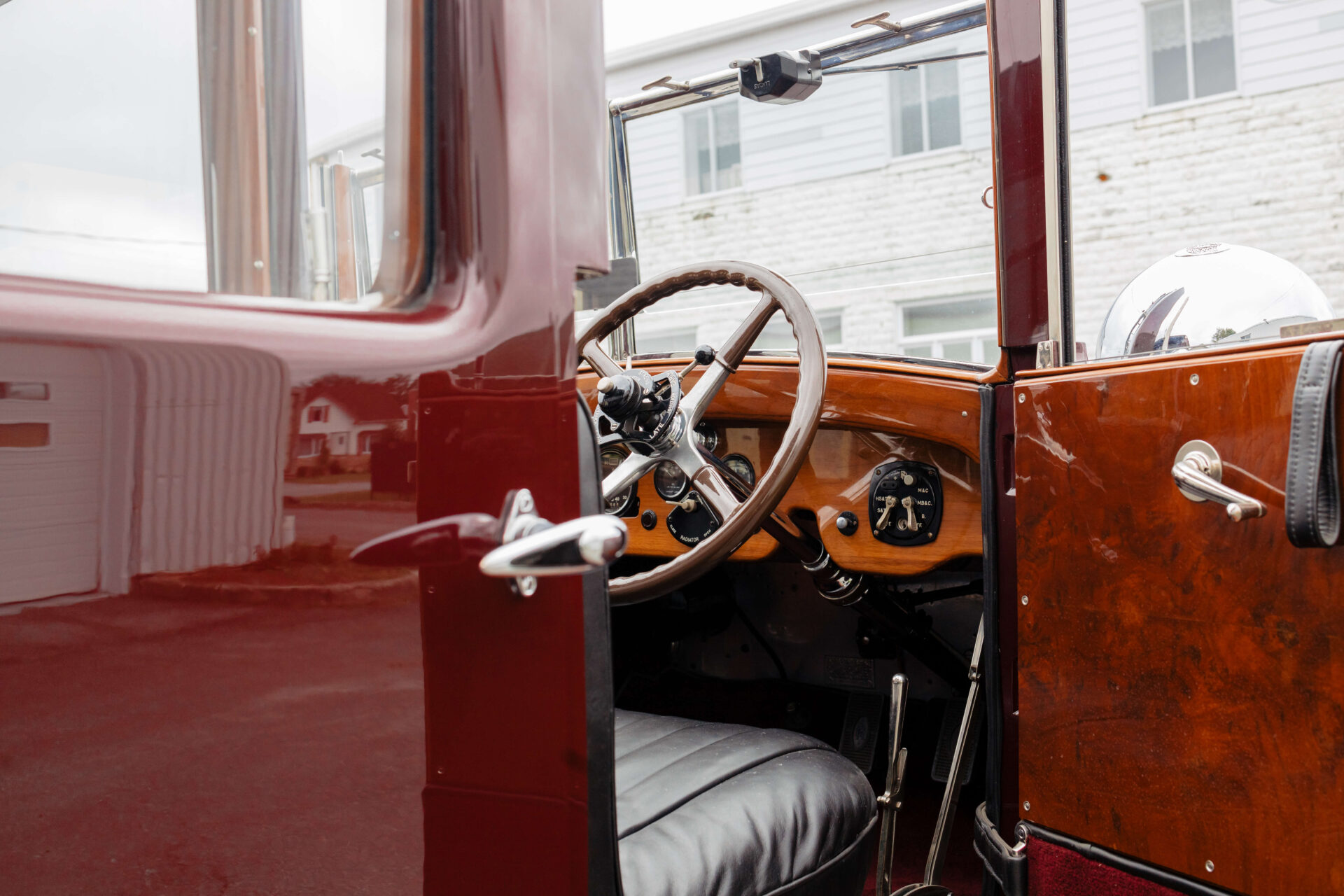 Interior of the Rolls-Royce Phantom I 1928. Black leather seat and wooden dashboard.