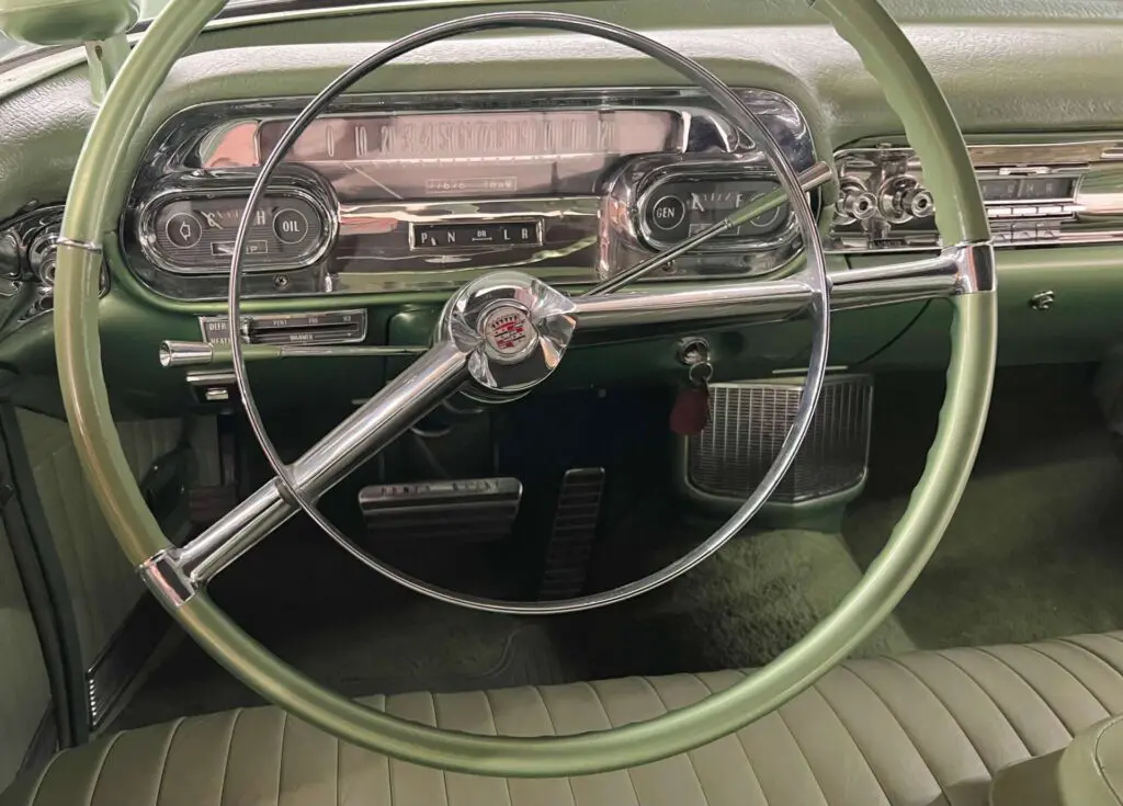 Close of of the steering wheel and dashboard of a green Cadillac