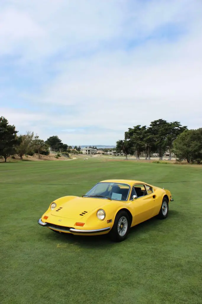 A yellow Dino is harmoniously placed on the green grass of a golf course