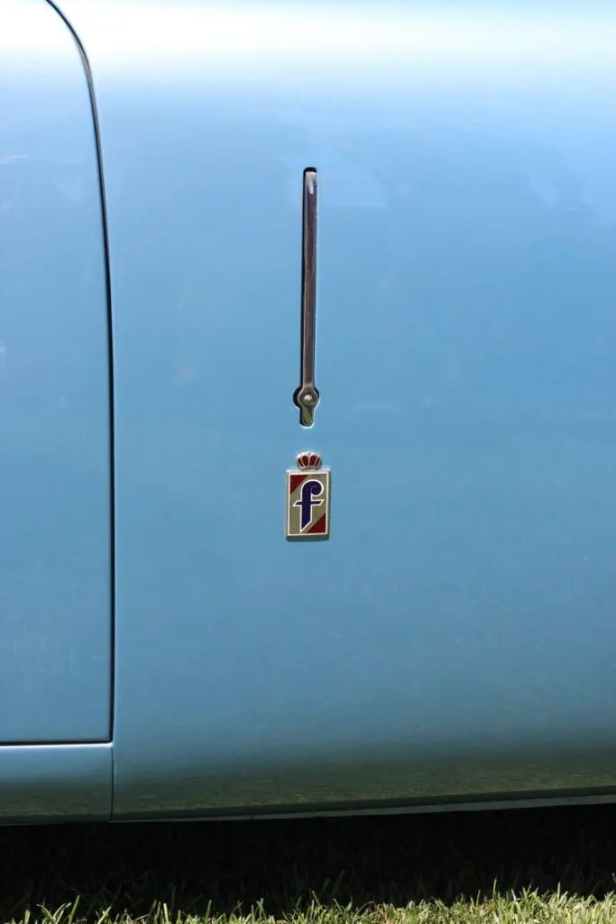 Close up of the Pininfarina badge on the side of a Cisitalia light blue car