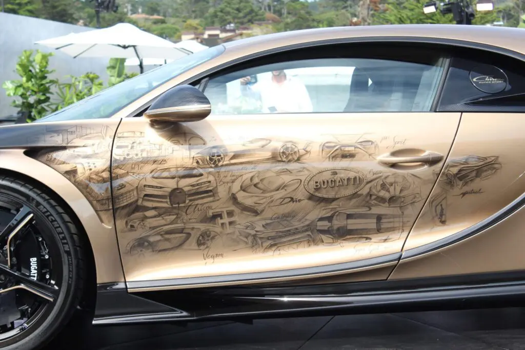 Left side of a Golden Bugatti. Black drawing of modern Bugattis on it.