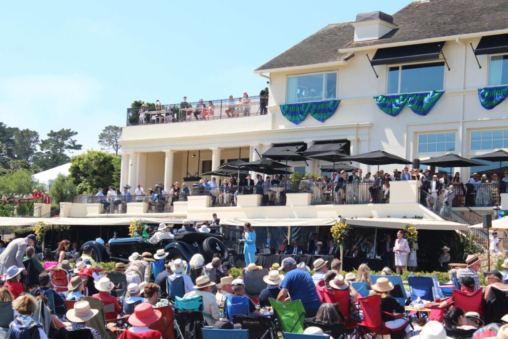 Crowd and podium at the Pebble Beach Concours d'Elegance 2023. The lodge is seen in the background. People on every balcony.