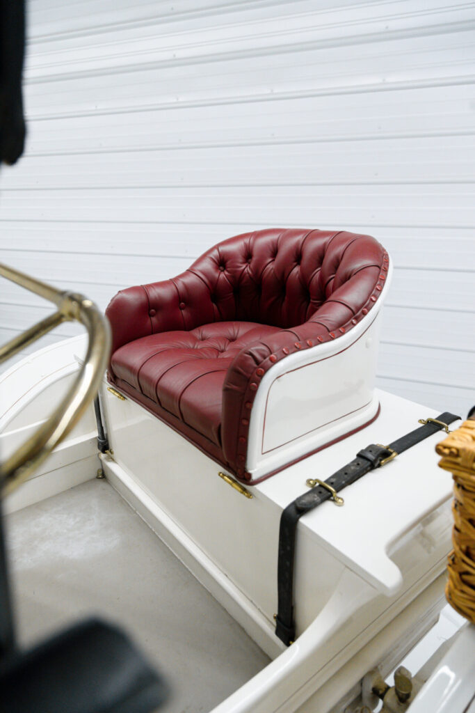 Back rumble seat on a white 1910 Buick. Typical of horseless carriage era cars, the seat is unprotected from the elements.