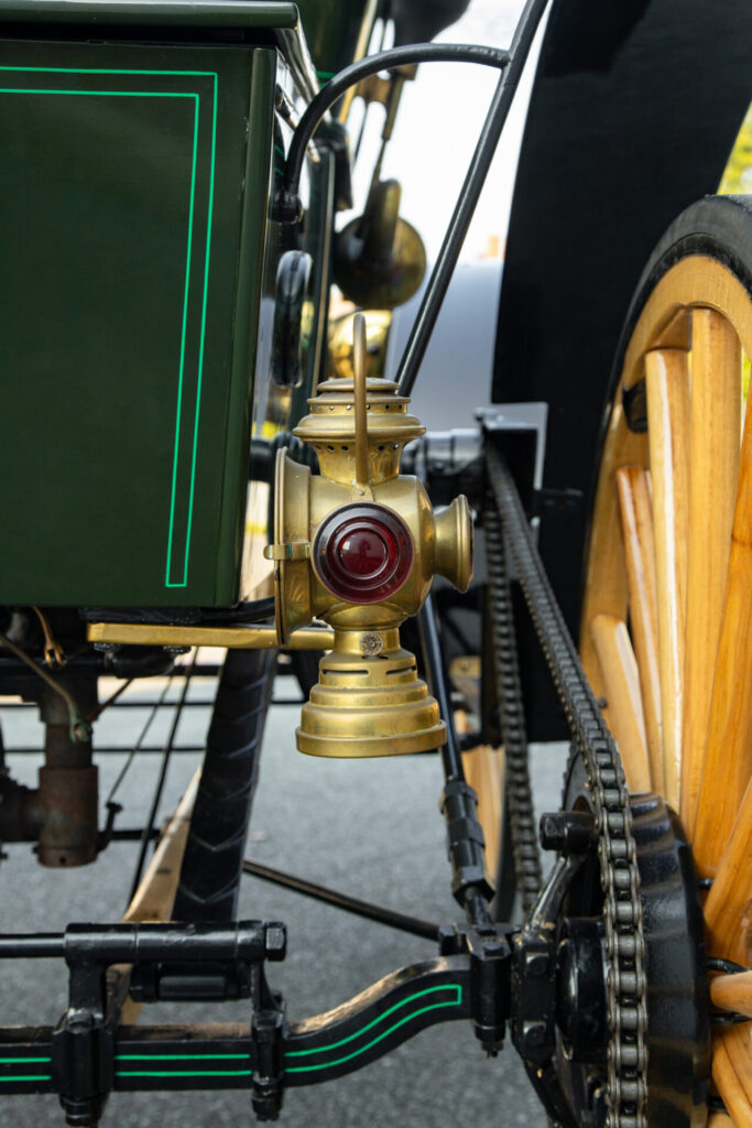 Close up of a bronze lantern at the back of the car. The chain drive is visible.