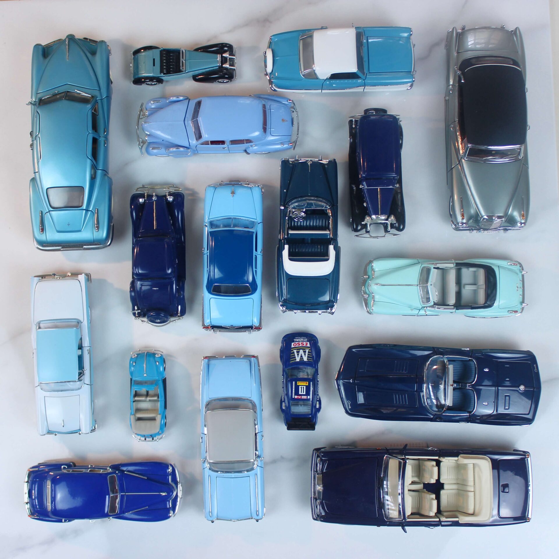 The car collecting hobby expanded to model cars: Model cars all in different shades of blue lines in a scare in the Knolling technique.