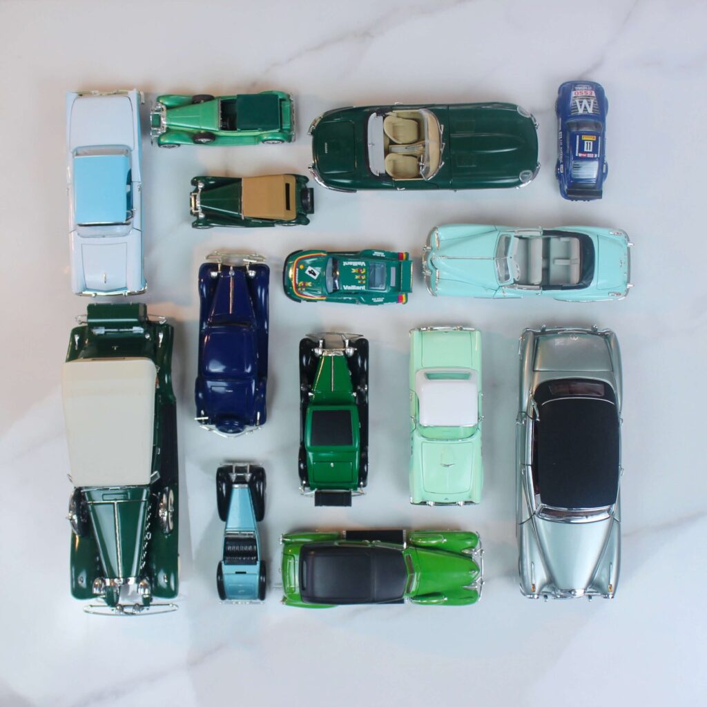 Model cars all in different shades of green lines in a scare in the Knolling technique. 