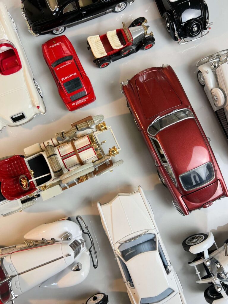 White, red and black model collectible cars viewed from the top on a white background.