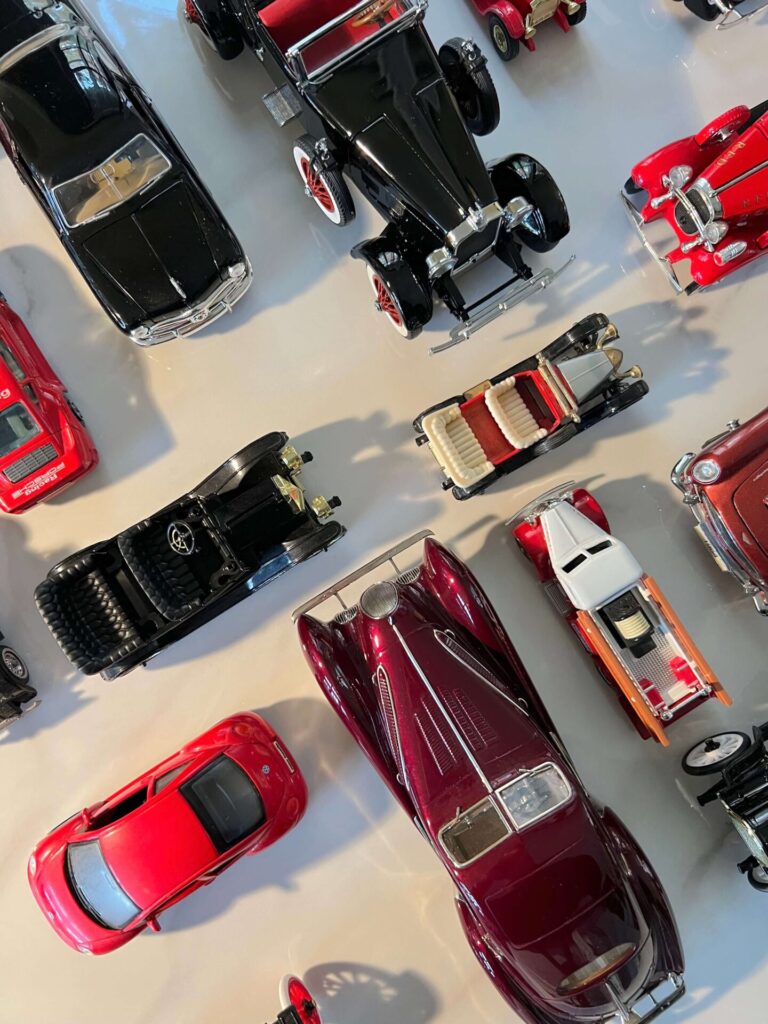 Red and black model collectible cars viewed from the top on a white background.