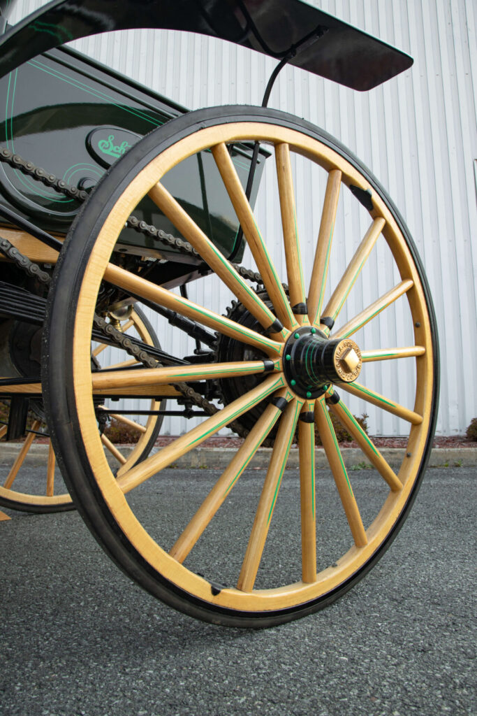 Gros plan sur une roue en bois avec un pneu en caoutchouc plein.