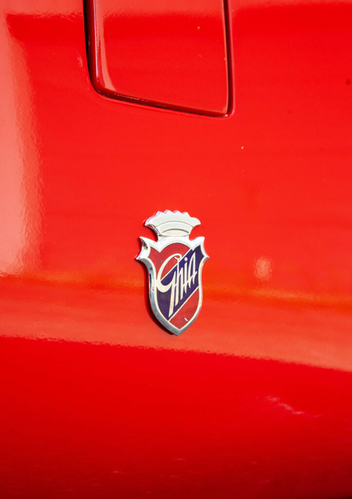 Close up of a Ghia badge on a red car