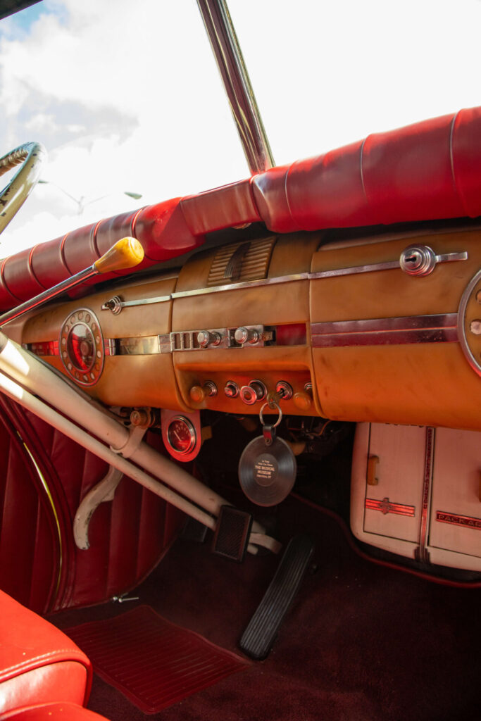 Intérieur d'une voiture ancienne. Le tableau de bord est en cuir rouge et en bois.