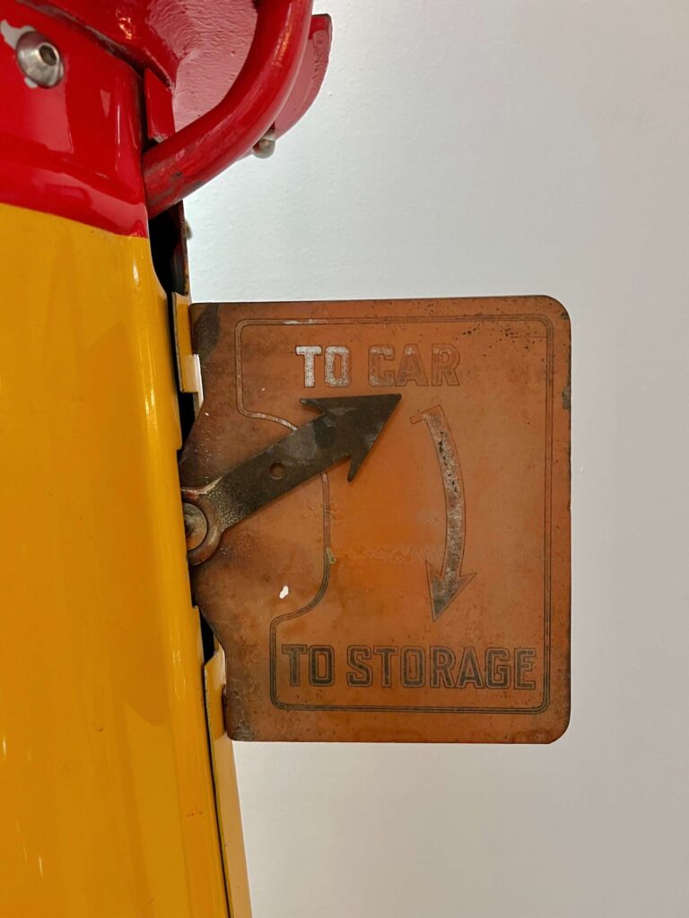 Gros plan sur un panneau avec une flèche pointant vers "vers la voiture" au lieu de "vers le stockage".