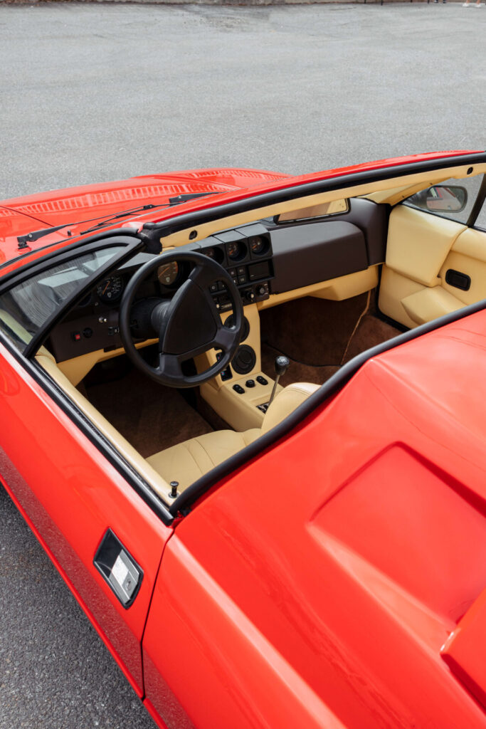 Vue depuis le toit targa ouvert d'une Lamborghini Jalpa rouge, l'intérieur en cuir luxueux est exposé.