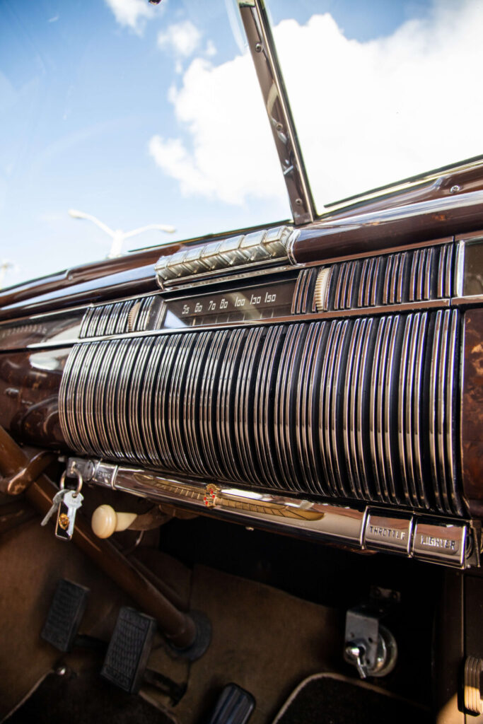 Brown and chrome radio pictured at an angle in the dashboard of an old car.