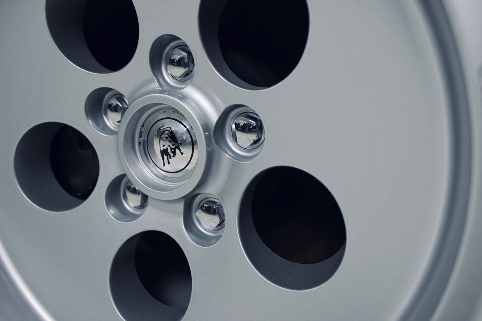 Close up of the rim of a Lamborghini car. The bull logo is visible in the center.