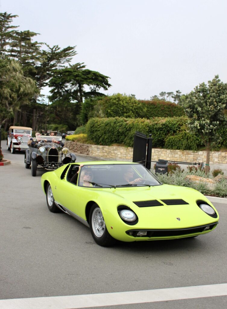 Une Lamborghini Miura vert citron photographiée en train de rouler lors du Pebble Beach Tour D'Elegance. La Miura est une voiture emblématique créée par Ferruccio Lamborghini.