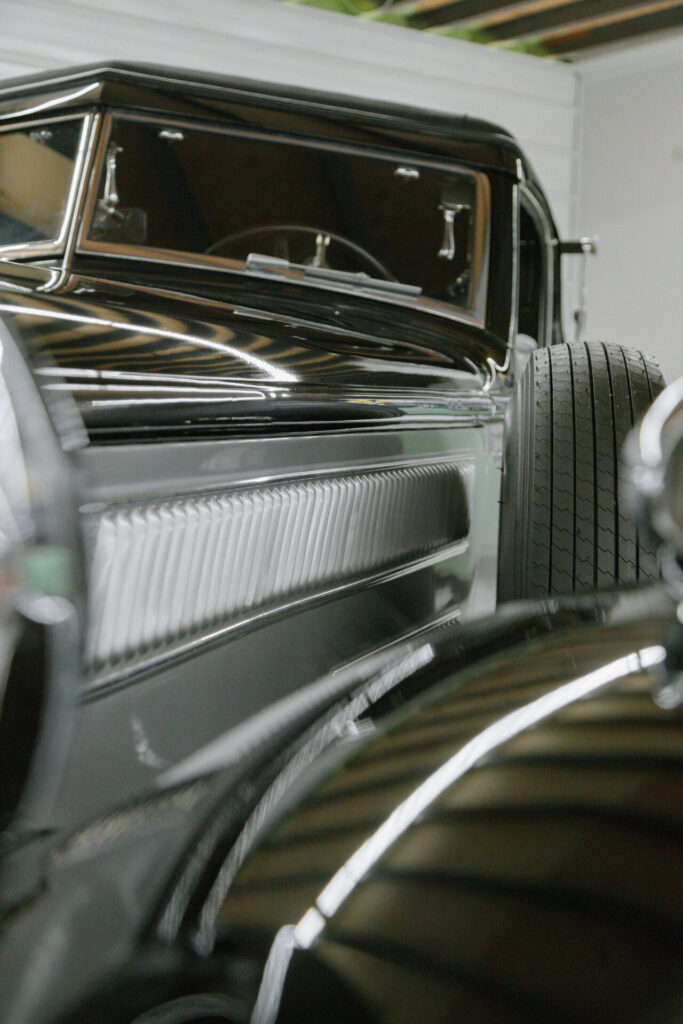 Side of a grey and black classic car.