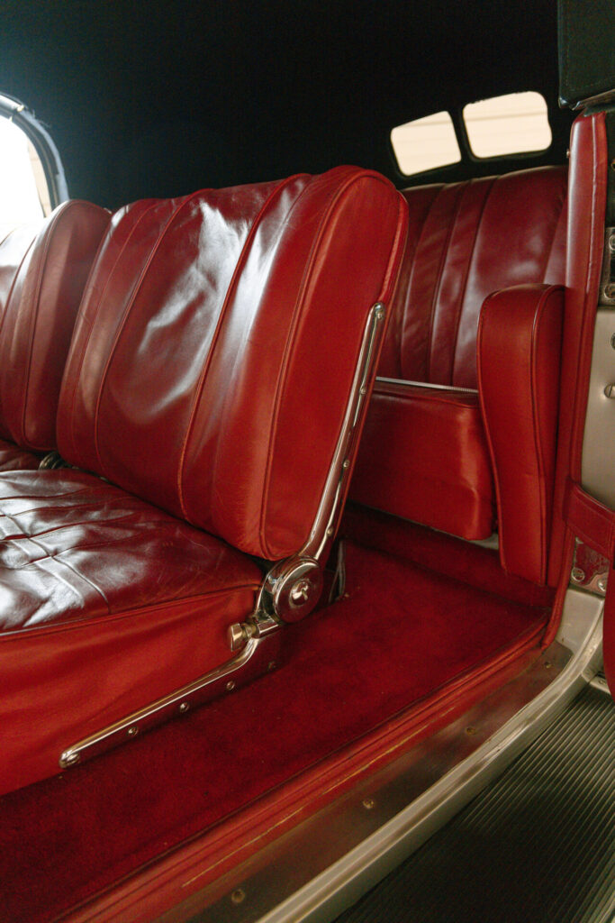 Red leather interior of a classic car. The lush carpet is also red