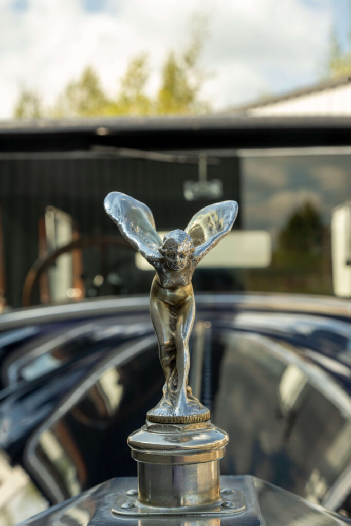 Spirit of Ecstasy mascot seen from the front on a dark, formal car.