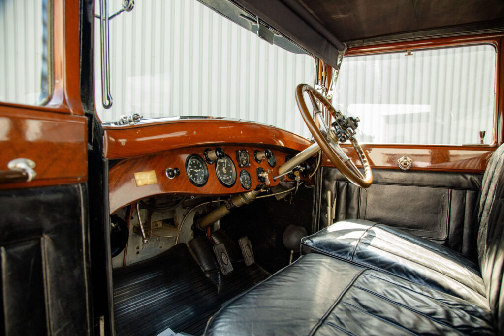 Interior of a Rolls-Royce Phantom I. The seats are made of black leather and the dashboard is made of wood.