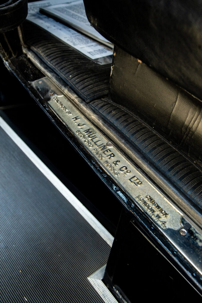 A metal plate indicating the coachbuilder H. J. Mulliner & Co on the inside frame of the passenger door.