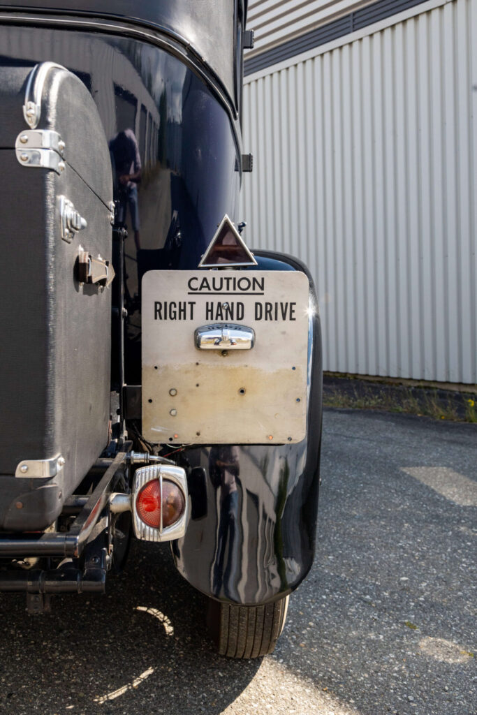 Sign that says "Caution, right hand drive" fixed to a car.