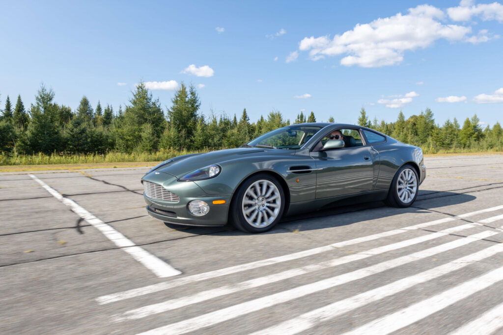 Green sports car pictured in motion on what appears to be a race course.