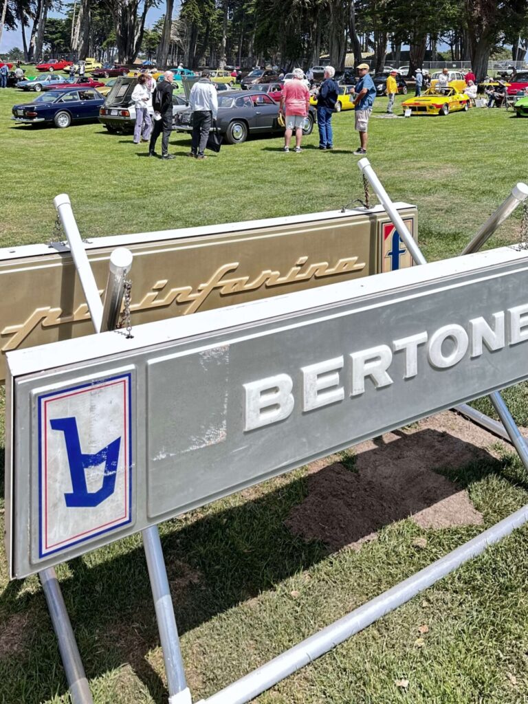 A Bertone sign hung on display at an event on grass.