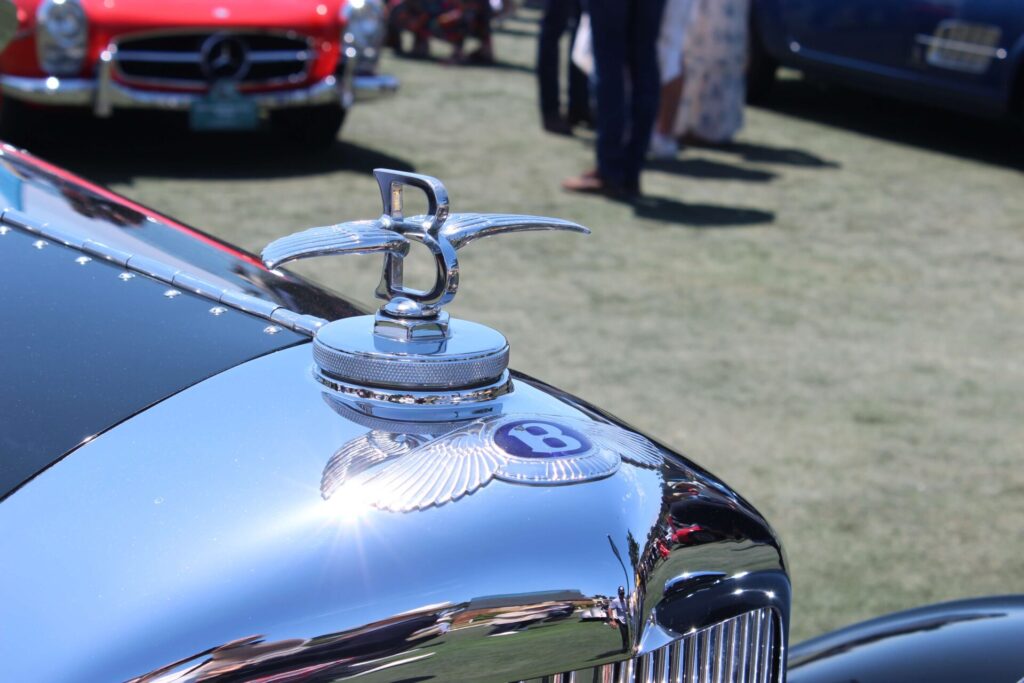 Old Bentley mascot mounted on a car. It's a capital B with wings coming out horizontally from it.