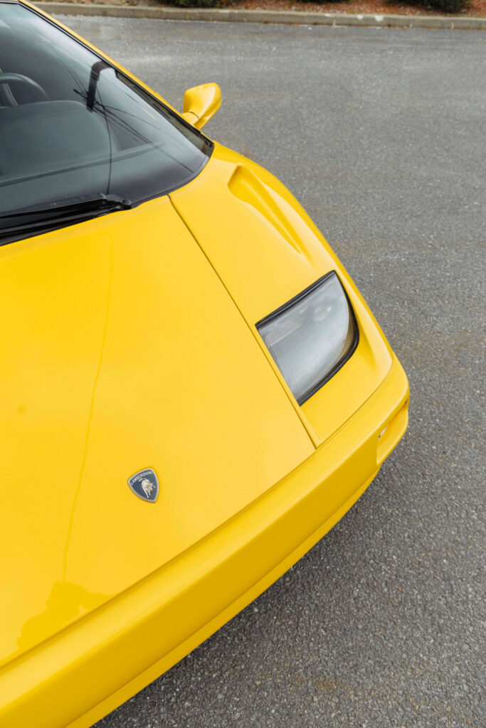 Une photo de l'avant d'une voiture Lamborghini jaune prise en angle depuis le dessus. 