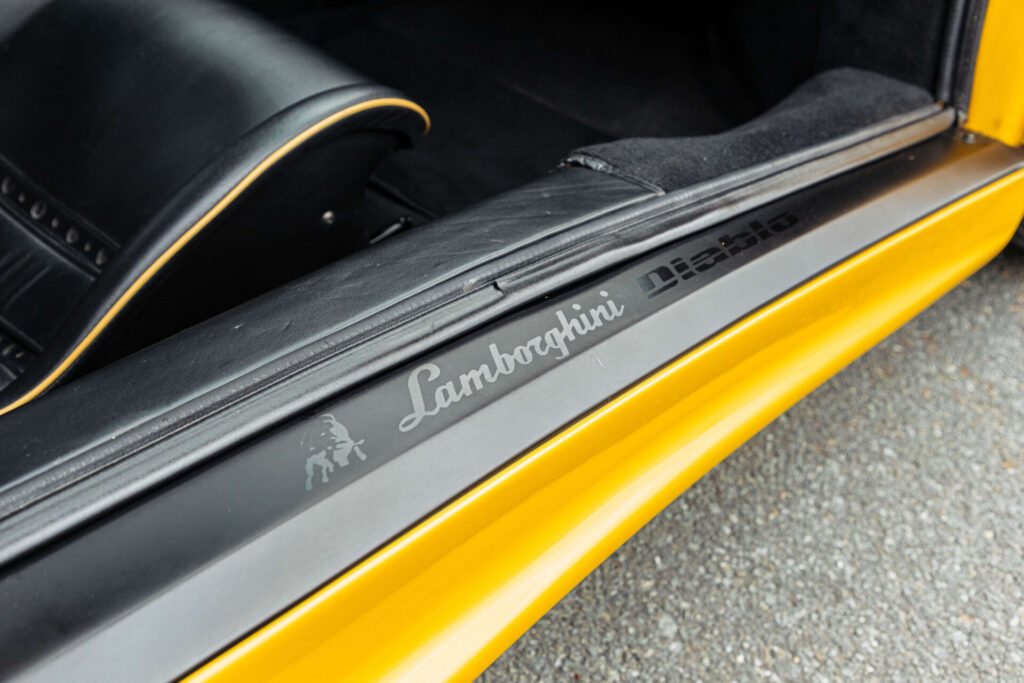 Le joint de porte d'une voiture jaune. Les mots Lamborghini et Diablo sont inscrits dans le plastique.